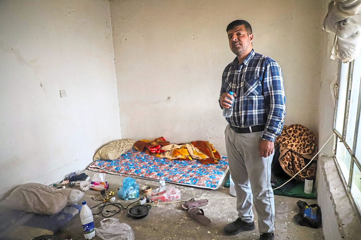 Mohamed Jalal posing for a picture in his apartment in Ranya. — AFP