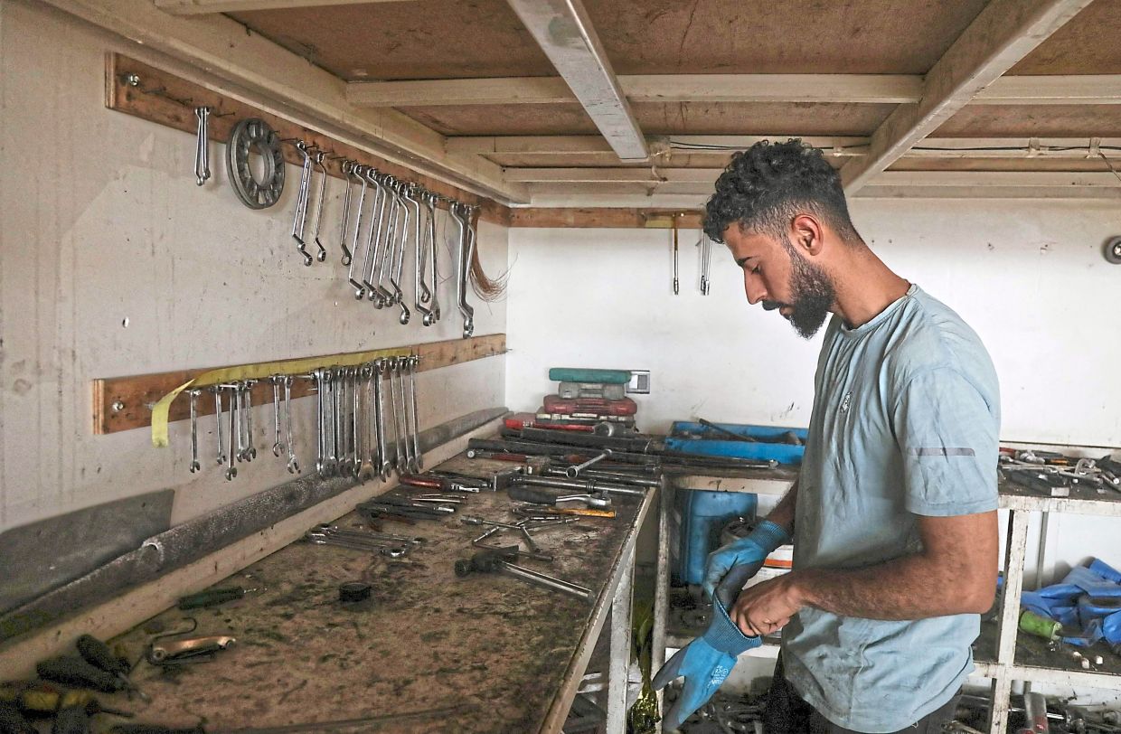 Mohamed Ismail working in his repair shop in Arbil. — AFP