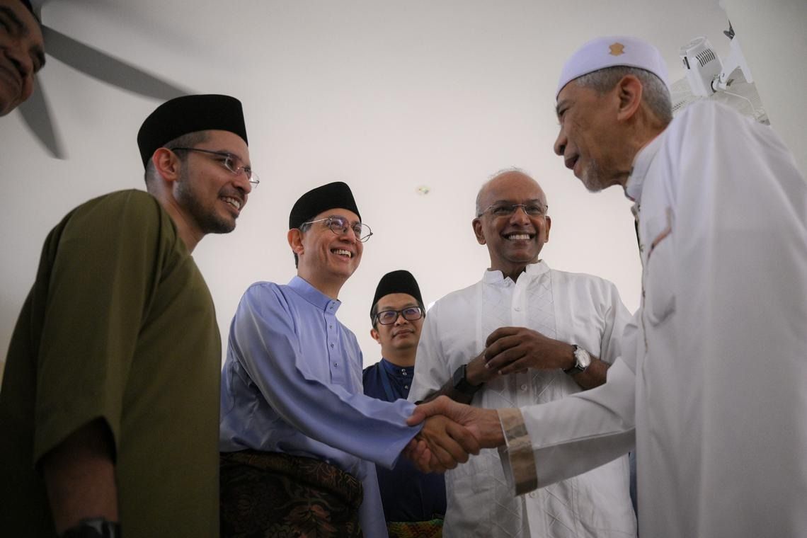 (From left) Nee Soon GRC MP Syed Harun Alhabsyi; Acting Minister-in-charge of Muslim Affairs Faishal Ibrahim; executive chairman of Masjid Darul Makmur Mohd Fairus Abdul Manaf; and Minister for Home Affairs K. Shanmugam greet a congregant after Hari Raya Aidiladha prayers. - Photo: ST 