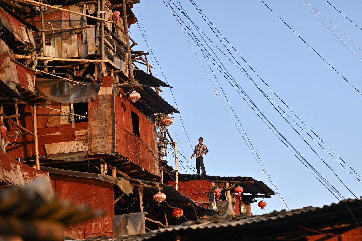 Chen Tianming at his house labelled China's strangest -- nail house -- households that refuse to move in the face of development plans -- in Xingyi, in southwest Guizhou province. Chen, 42, has spent seven years and over 100,000 yuan ($13,900) defying authorities' demolition notices to turn his family's humble stone bungalow on the outskirts of Xingyi city into a bewildering 10-storey pyramid-shaped home that has drawn comparisons on Chinese social media to the fantastical creations of Japanese animator Hayao Miyazaki. -- Photo by Pedro PARDO / AFP
