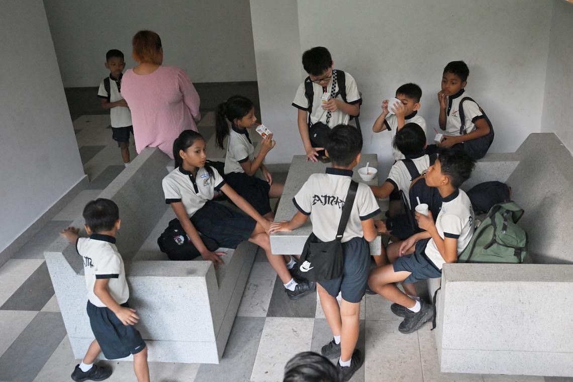 Breakfast starts at 6.30am at the void deck of Block 228A Ang Mo Kio Street 23, where the children gather at tables to eat. - Photo: ST