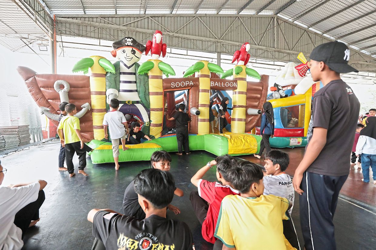 (Above and below) Visitors to the event having fun at the inflatable playground, playing carrom, and interacting with animals at the petting zoo. — Photos: YAP CHEE HONG/The Star