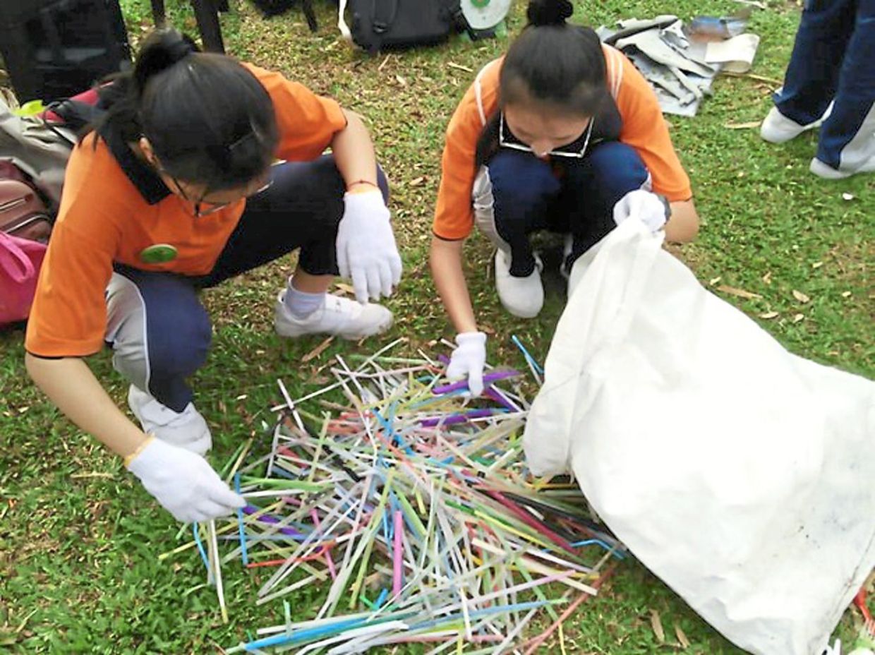 Students separating straws collected at the beach clean-up in Pantai Bersih, Butterworth.