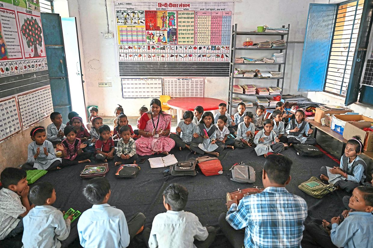 A dozen children aged five and six are trying to identify Hindi words beginning with the ‘p’ sound. After a spontaneous ‘papa’, the children unanimously agree on ‘papaya’, spelt out at the top of their lungs by the entire class. Photo: MONEY SHARMA/AFP