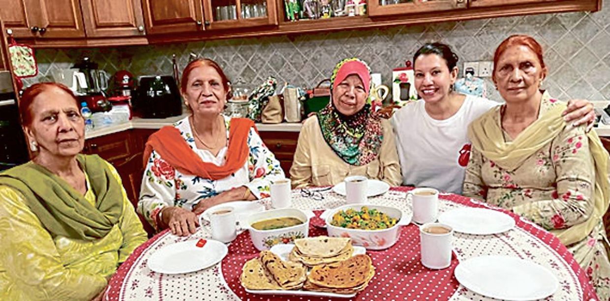 Kalsom has preserved many strong friendships over the years. She is pictured here with the Sidhu family, her friends of over 30 years who shared their recipe for aloo ghobi with her. 