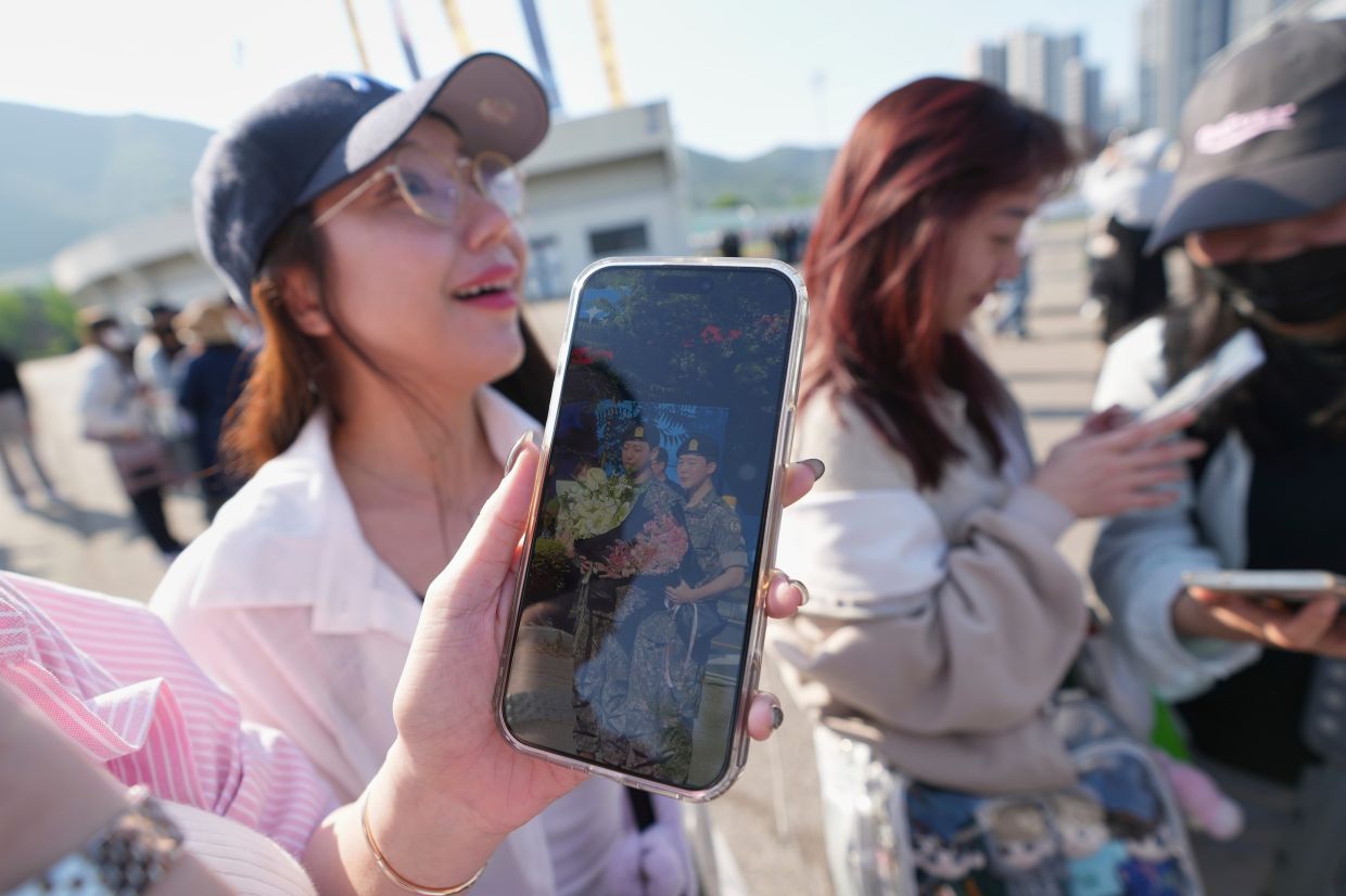 Fans reacting after catching sight of BTS band members Jimin and Jung Kook as they were discharged in Yeoncheon on June 11, 2025. - AP