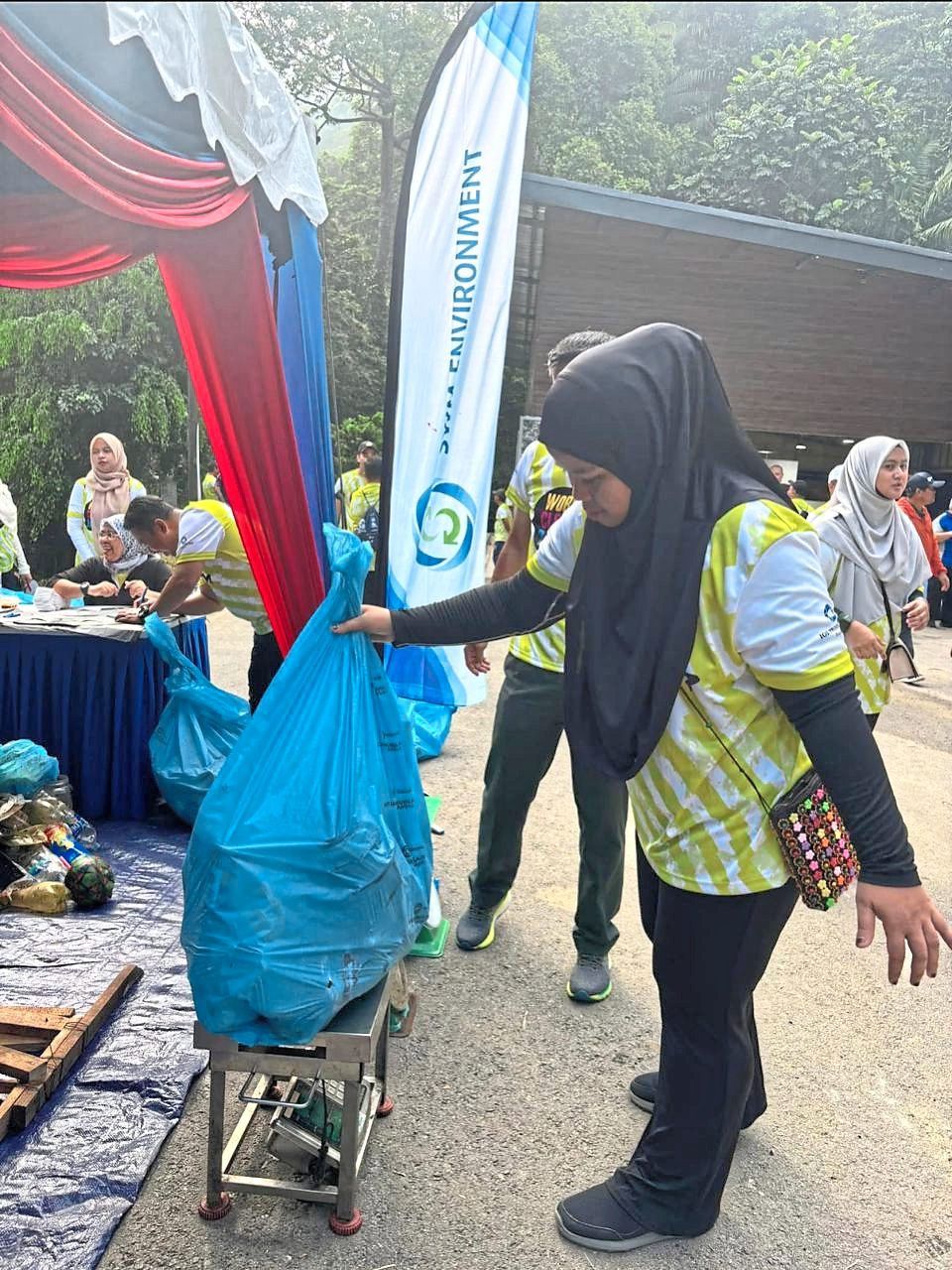 A volunteer weighing rubbish collected from a clean-up programme at Gunung Pulai.