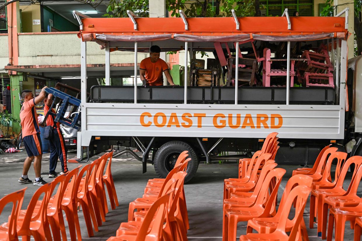 Coast Guard personnel load chairs on a truck as they help with the cleaning of an elementary school in Manila on Friday, June 13, 2025, ahead of the opening of classes on June 16. -- Photo by Jam STA ROSA / AFP