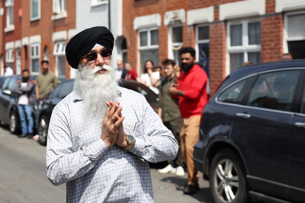 Prayers are said in the street outside the family home of Vishwash Kumar Ramesh, the sole survivor of an Air India crash in Ahmedabad City in India, in Leicester, central England on Friday, June 13, 2025. -- We are happy-- to have Vishwash back, but -- we are heartbroken-- : In England, the family of the passenger who survived the Air India crash is torn between relief at knowing he is alive and sadness at the death of his brother, also on the plane. Since the crash of Air India Flight 171, the small street in a modest Leicester neighborhood where Vishwash and Ajay Kumar Ramesh's parents and younger brother live has been packed. -- Photo by Darren Staples / AFP