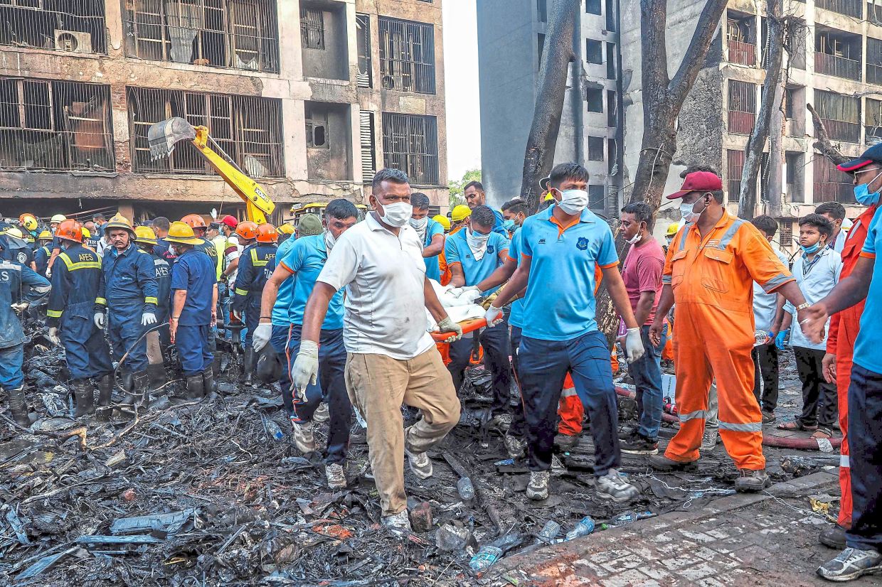 Combing through: Rescue officials carrying a victim’s body at the site where Air India Flight 171 crashed in Ahmedabad. — AFP