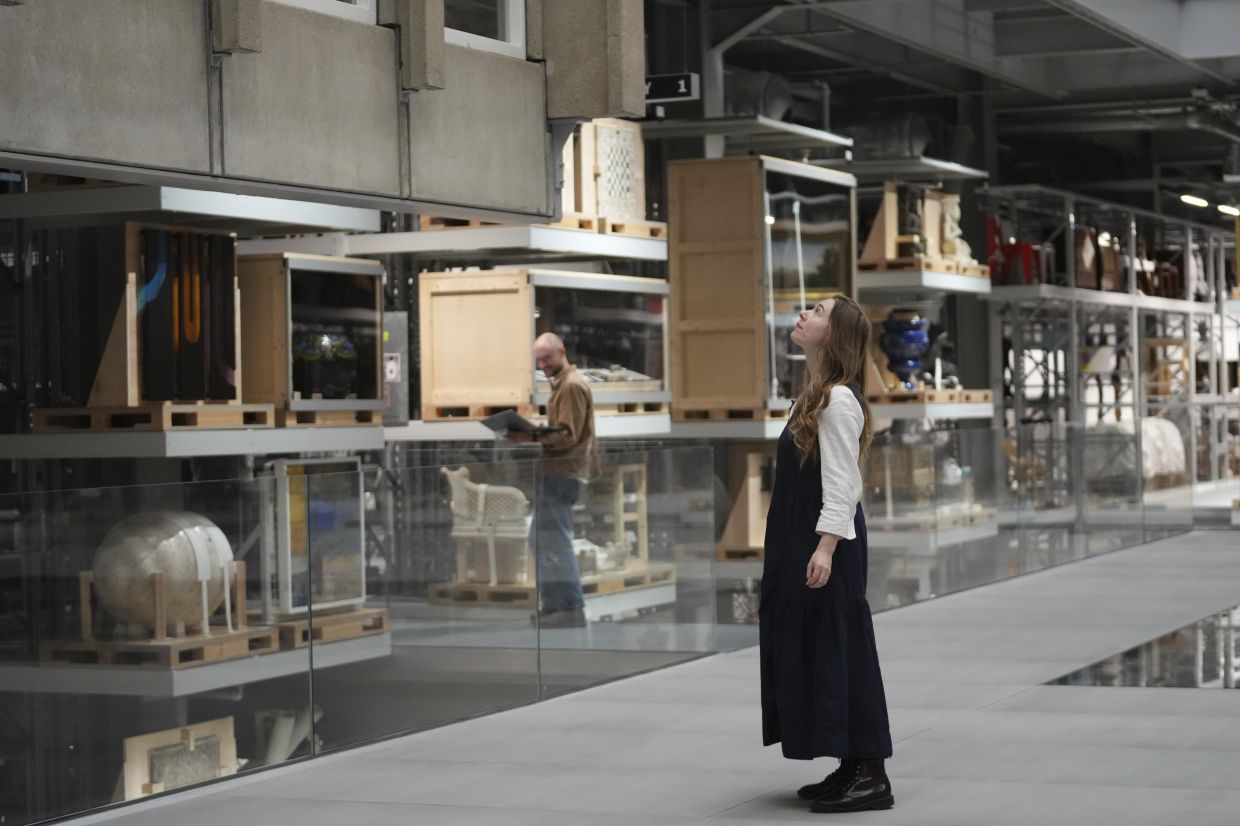 Georgia Haseldine, senior curator, looks up at the section of Robin Hood Gardens facade on display at the V&A Storehouse in London. Photo: AP 