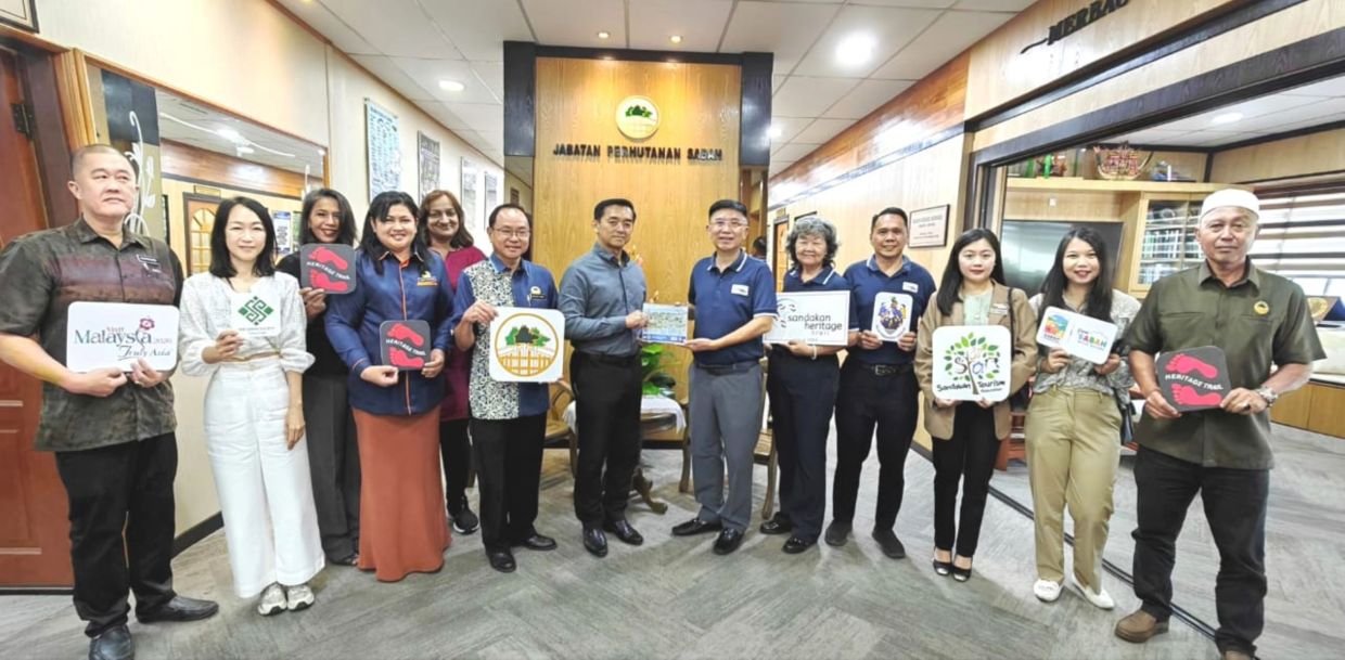 Sabah Forestry Department’s chief conservator of forests Sabah Datuk Frederick Kugan (seventh right) receiving a momento from the Sandakan Heritage Trail founder and chairman Lai King Hang during their recent courtesy call. 