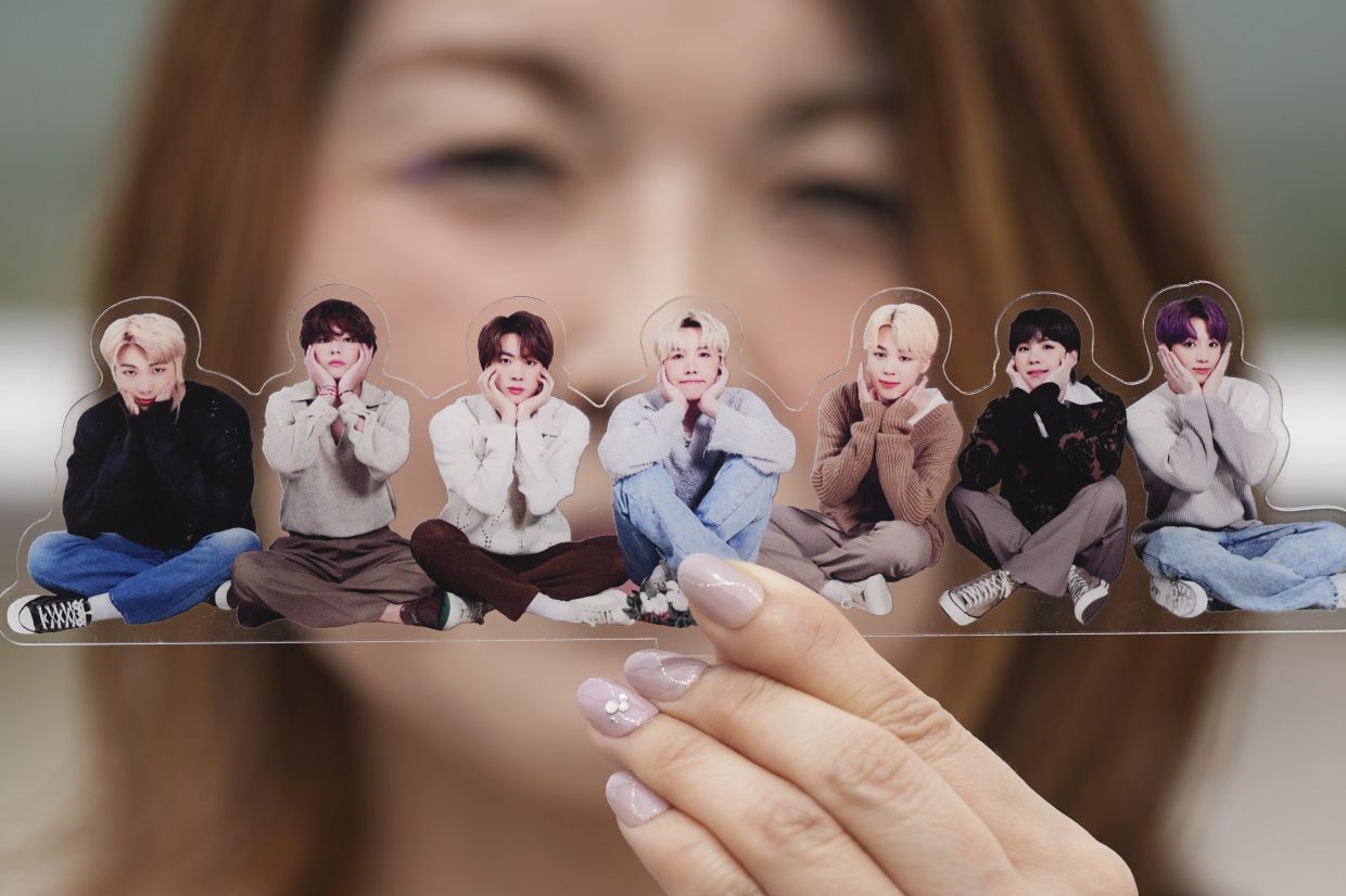 A fan of K-pop band BTS poses with a group photo of BTS during the annual 2025 BTS Festa celebrating the BTS' debut anniversary in Goyang, South Korea, Friday, June 13, 2025. - Photo: AP 