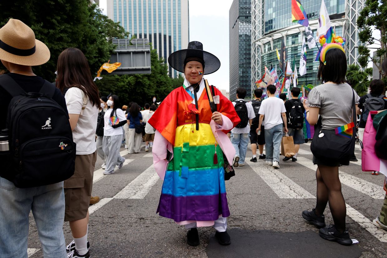 A person wearing a rainbow coloured Korean traditional clothing poses for a photogragh as South Korea's LGBTQ community and supporters attend a Pride parade, during the Seoul Queer Culture Festival, in Seoul, South Korea, on Saturday, June 14, 2025. Photo: REUTERS/Kim Soo-hyeon