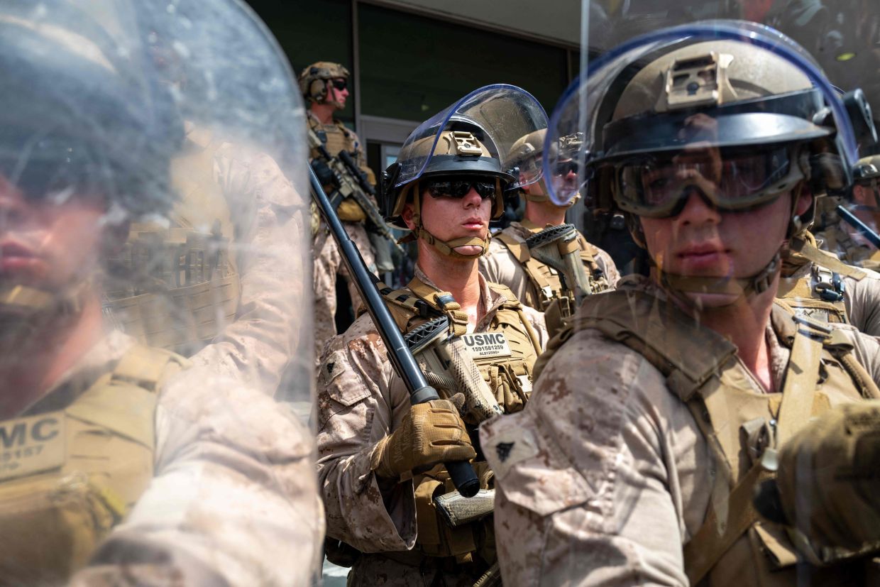 In LA, US Marines guard against protesters outside a federal building during an anti-Trump 'No Kings Day' demonstration. — AFP