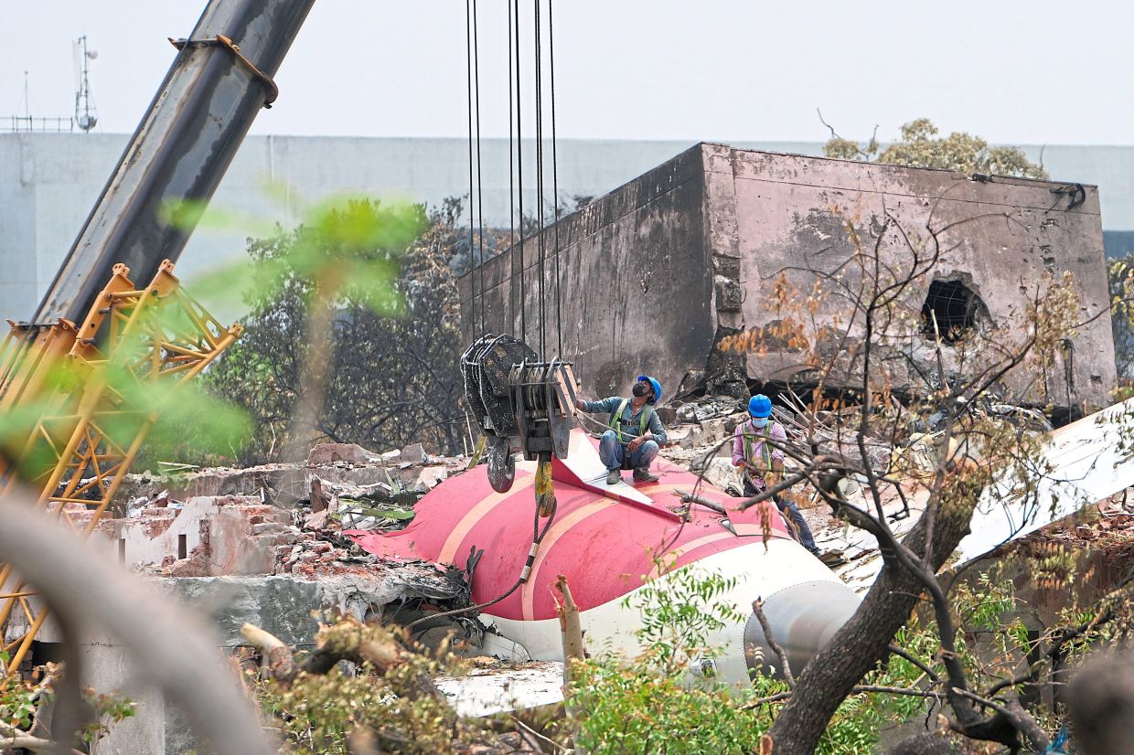 A crew preparing to remove parts of the Air India plane from the roof of a building in Ahmedabad. — AFP/AP 