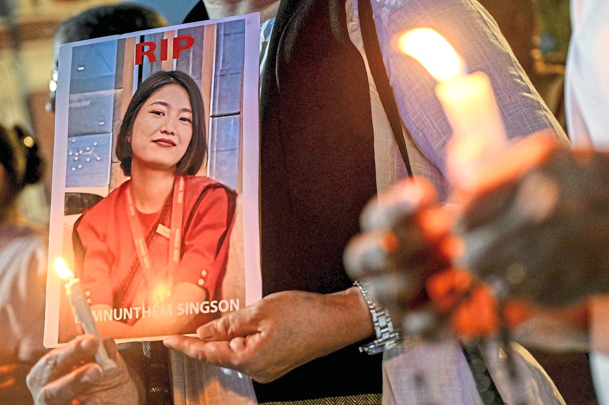 Remembering the departed: Members of a Christian community holding a portrait of Air India cabin crew member Lamnunthem Singson, who died in the crash, during a candlelight prayer service for the victims of the Ahmedabad flight disaster at Sacred Heart Cathedral in New Delhi. — AFP 