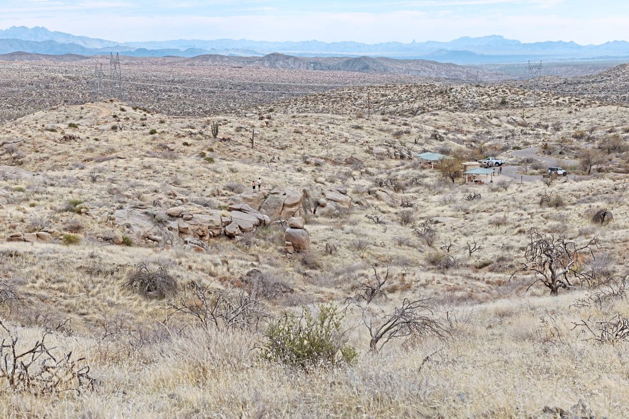 Parking and shade structures (right) at a trailhead in an area where abundant red brome, an invasive species of grass, raises the wildfire risk, in the Tonto National Forest.
