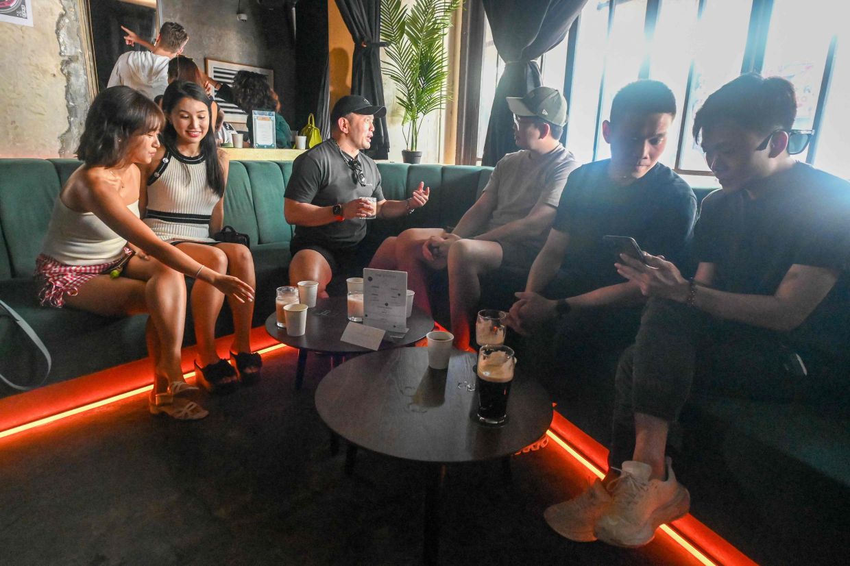 People mingling over coffee drinks at an alcohol-free clubbing event in Singapore.
