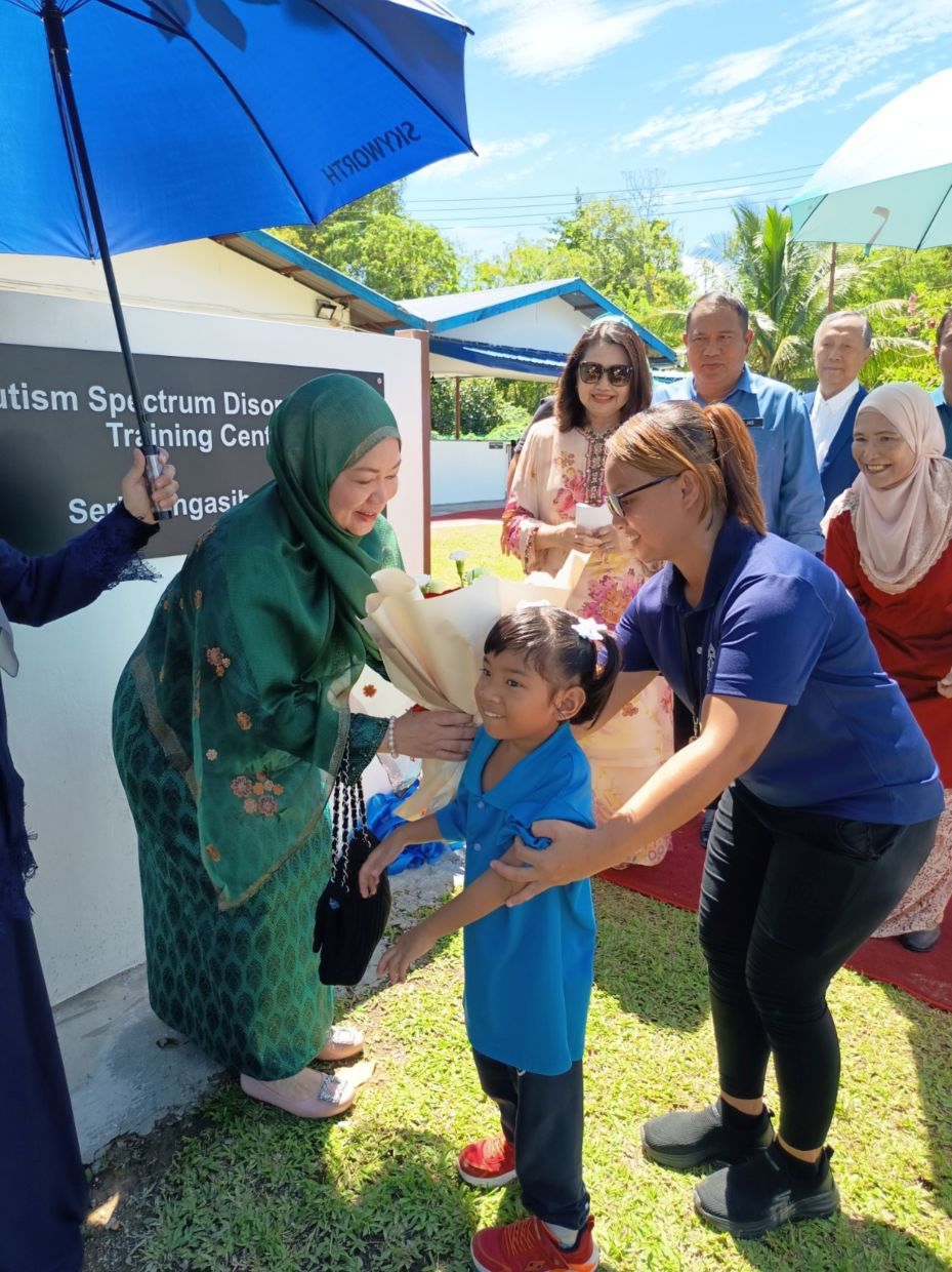 Her Royal Highness YAM Paduka Puteri Tunku Mariamz Al-Marhum Sultan Iskandar receiving a bouquet of flowers from one of the Seri Mengasih’s Autism Spectrum Disorder (ASD) Training Centre pupils.