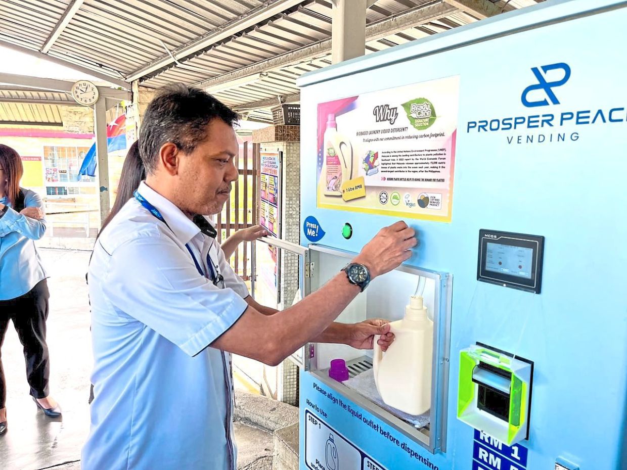 Zulkurnain dispensing detergent at the refilling kiosk after the launch.