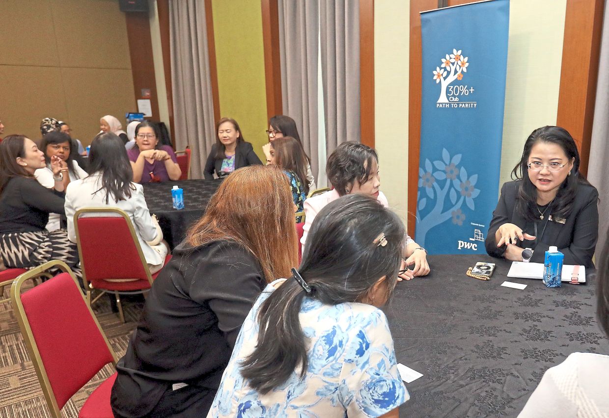 Wang (right) leading a roundtable discussion with a group of participants.