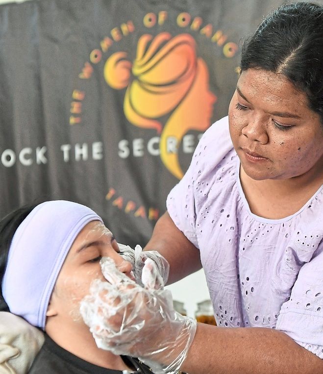 A Kowast member showing how to use a beauty product, which is made by the cooperative comprising 15 Semai women. — Photos: Bernama