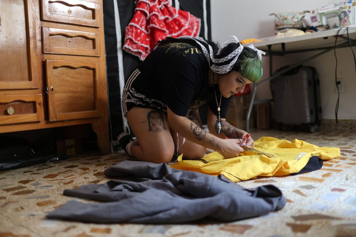 Italia Segovia, known as Kumiko, sews a second-hand blazer she bought at a street market for her brand Chicanjuku. Photo: Reuters