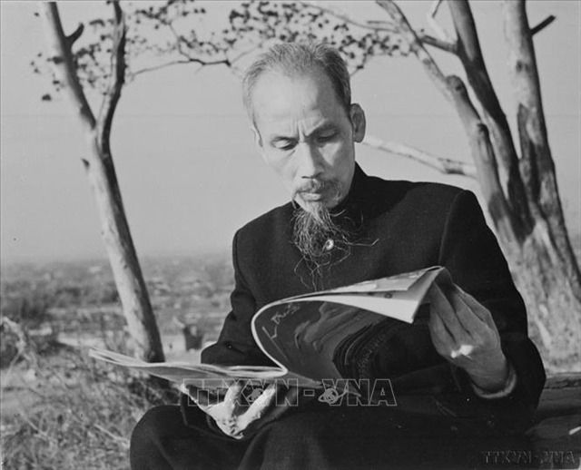 President Ho Chi Minh reading a Chinese newspaper during a visit to China in 1953. - Photo: VNA/VNS