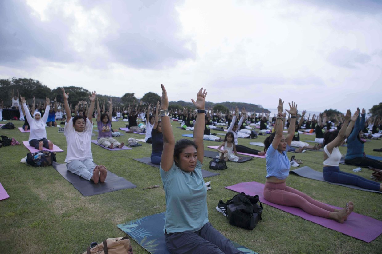 Participants perform yoga on International Day of Yoga in Nusa Dua, Bali, Indonesia, Saturday, June 21, 2025.-- AP Photo/Firdia Lisnawati