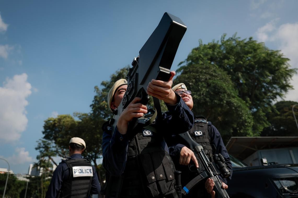 Strategic location response officers from the Protective Security Command demonstrating a handheld drone jammer. -- ST PHOTO: GAVIN FOO