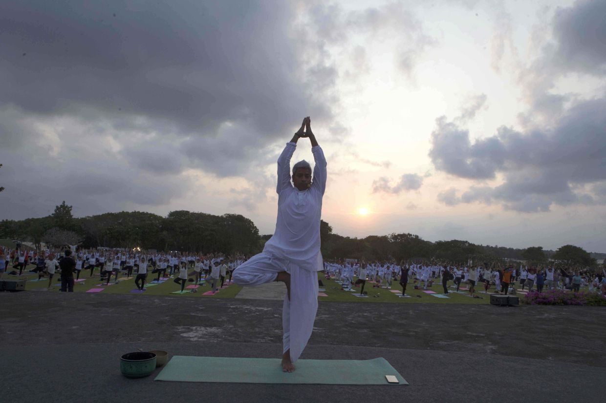 Naveen Meghwal from Indian Consulate performs yoga on International Day of Yoga in Nusa Dua, Bali, Indonesia. -- AP Photo/Firdia Lisnawati