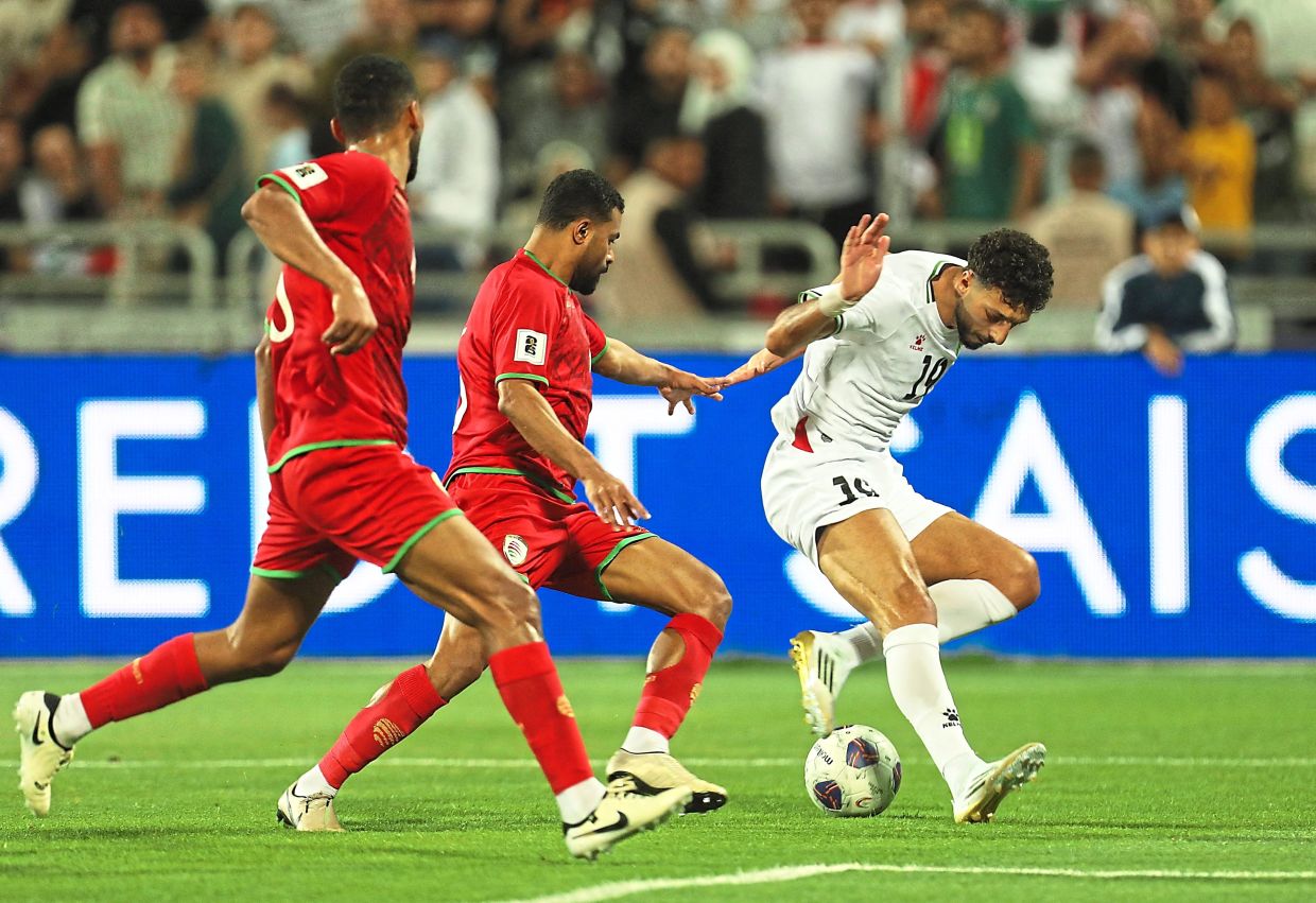 Palestine’s Wessam Ali tries to get past two Oman players. — Reuters