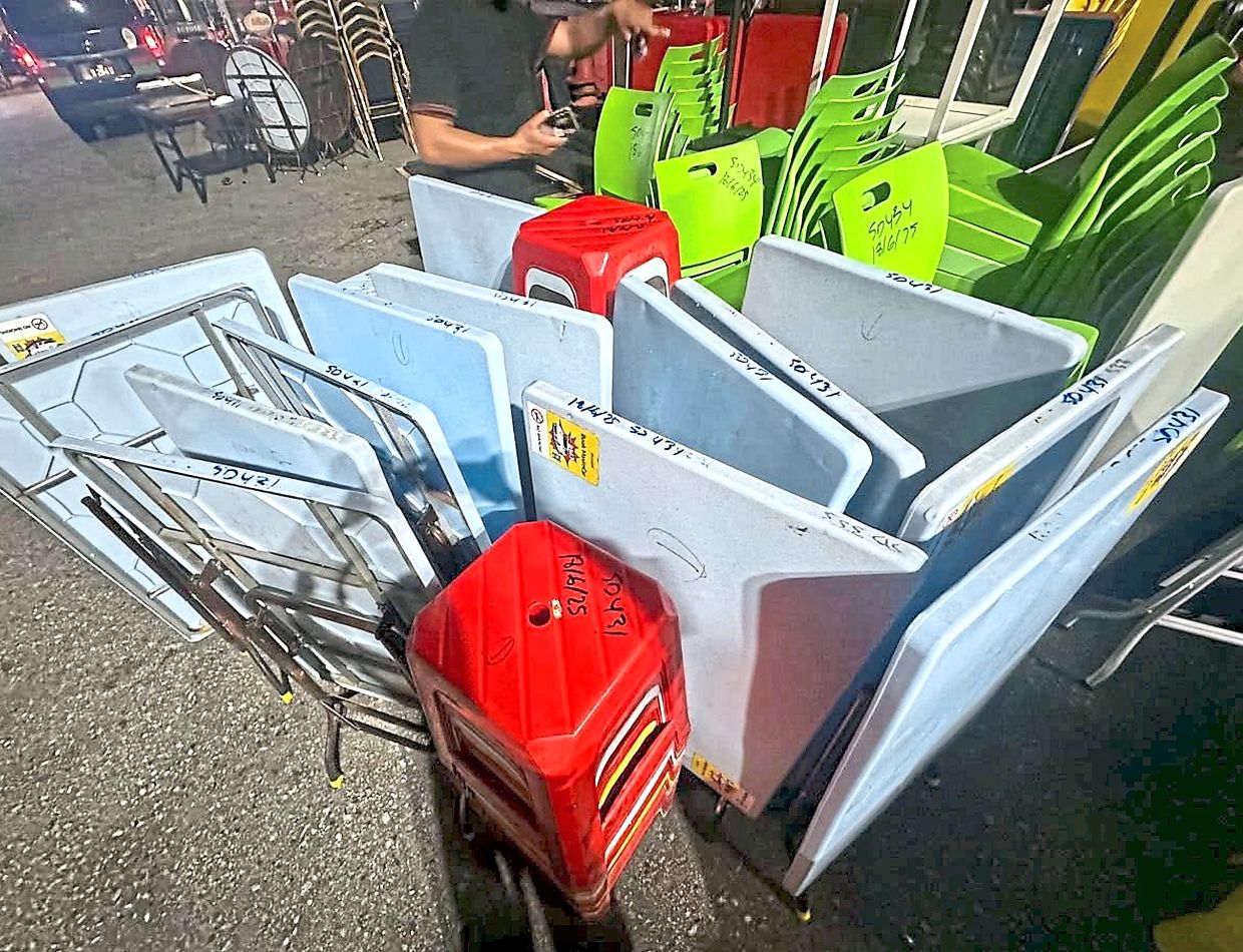 DBKL enforcement officers loading seized tables and stools onto a lorry during an operation outside a shopping complex in Bukit Bintang.