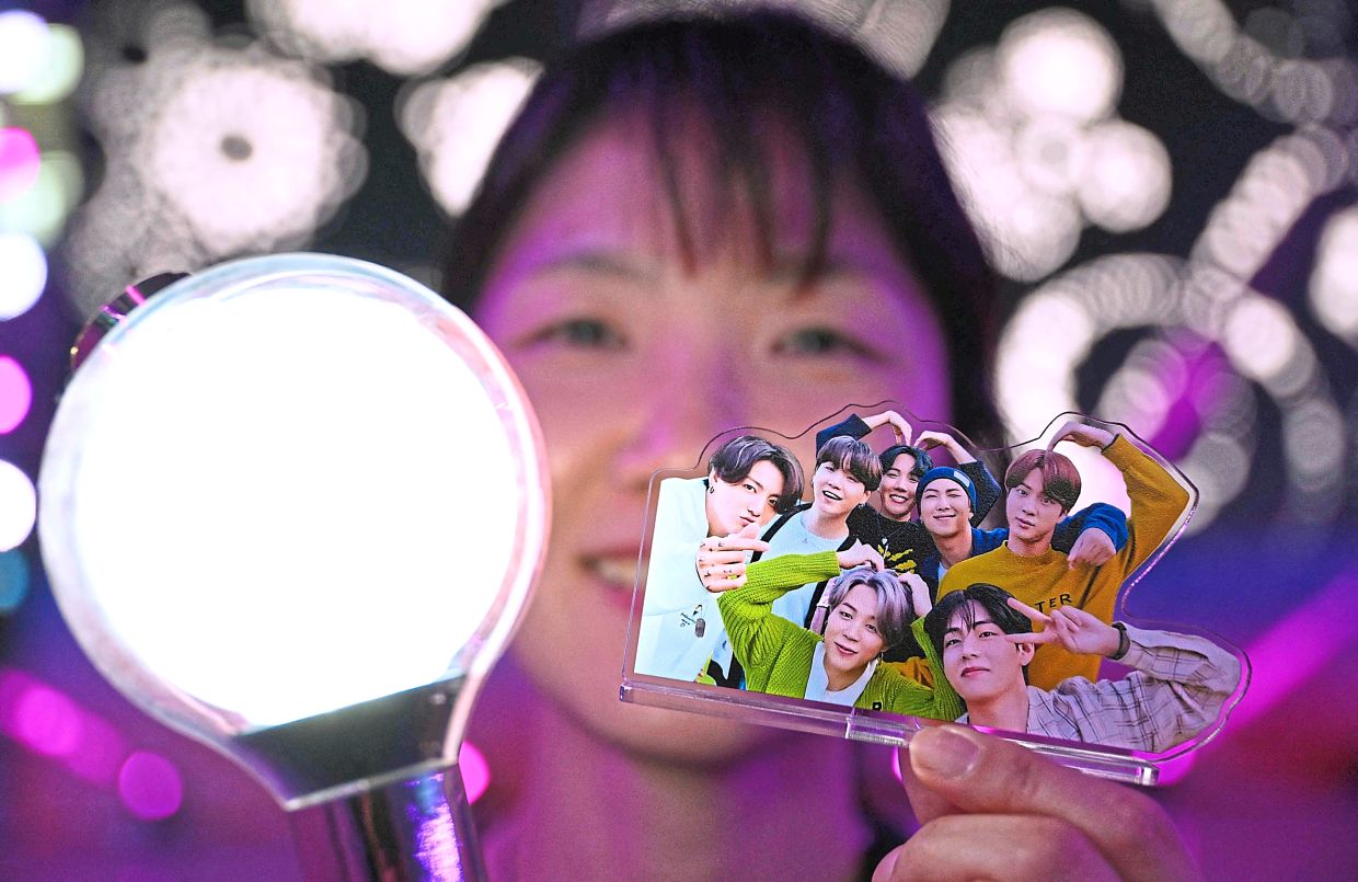 A fan holding an ARMY Bomb lightstick and a standee of BTS members during the BTS Festa­ in Goyang. — AFP