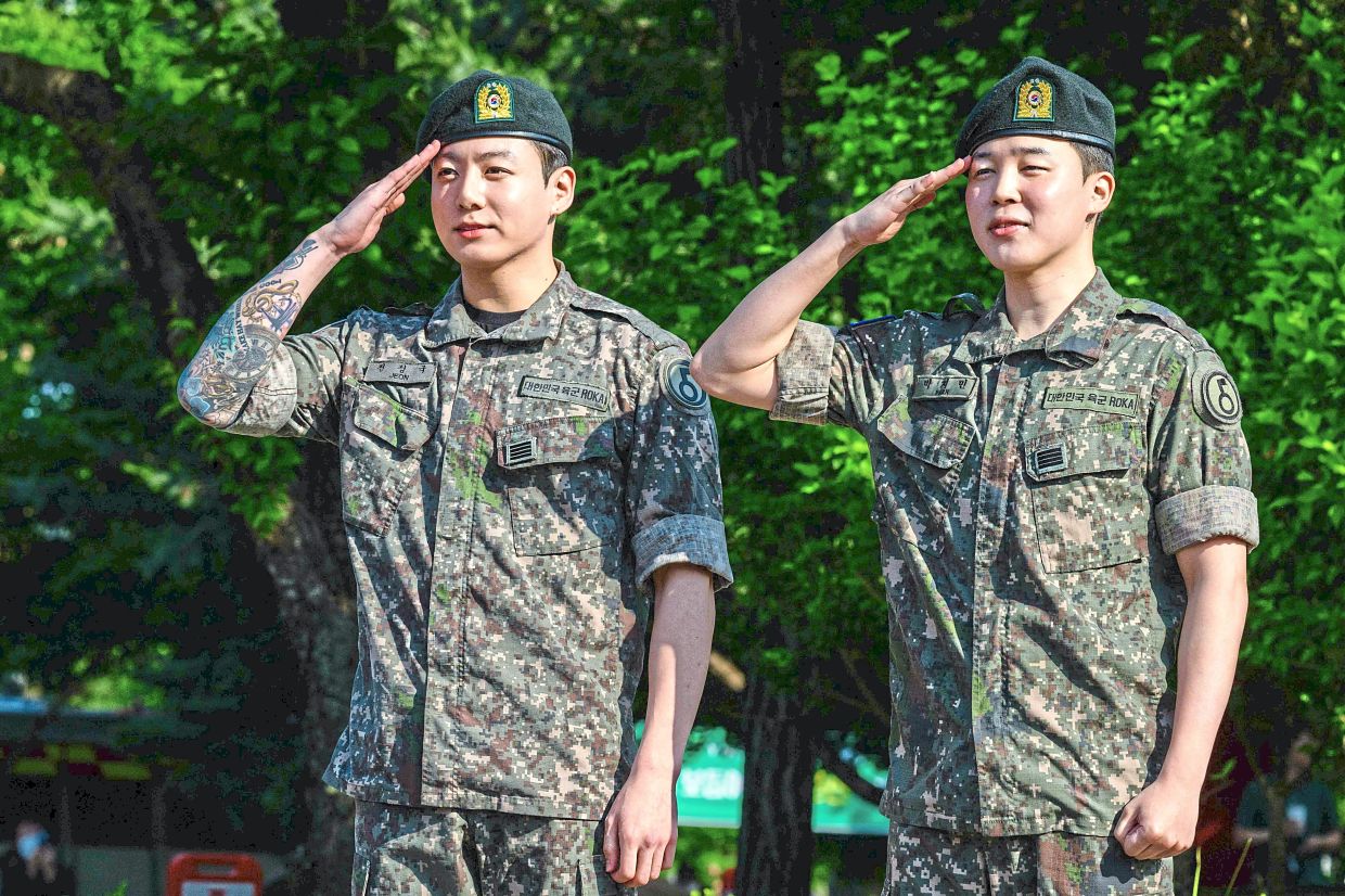 A matter of identity: (from left) Jung-kook and Ji-min saluting at an outdoor sporting facility in Yeoncheon, shortly after their release from 18 months of South Korean military service. — AFP