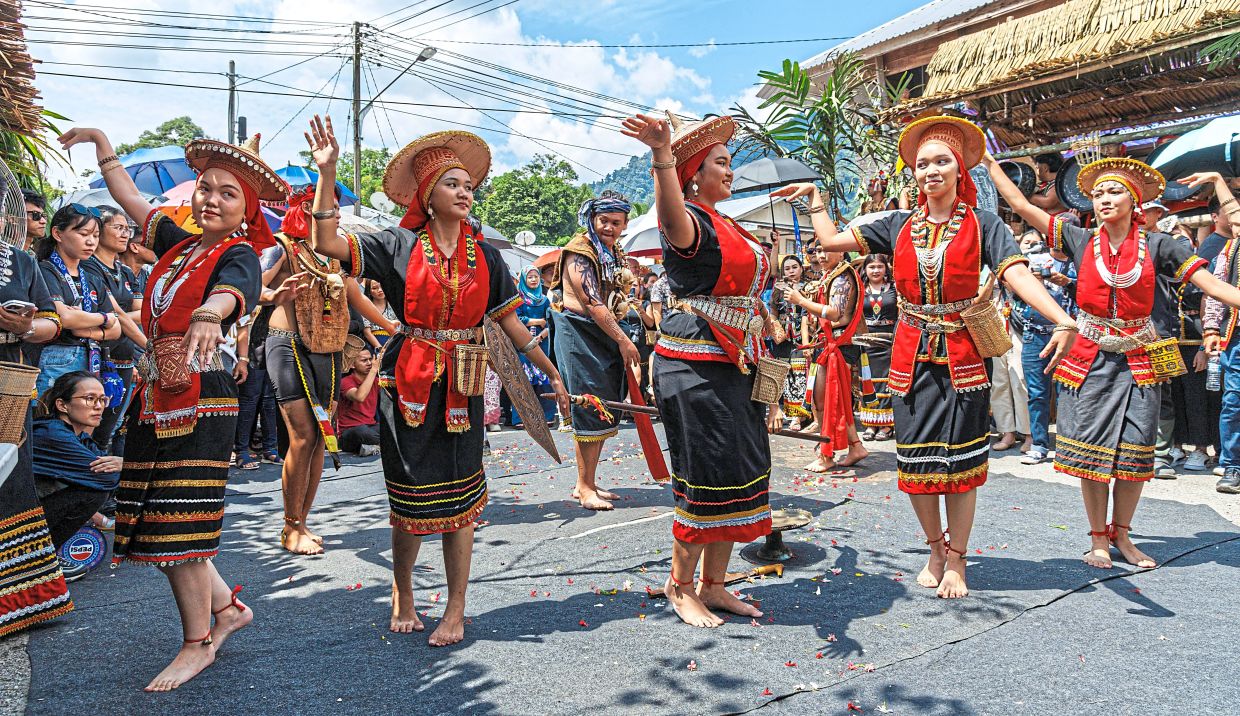 Parade participants performing a traditional dance along the route.