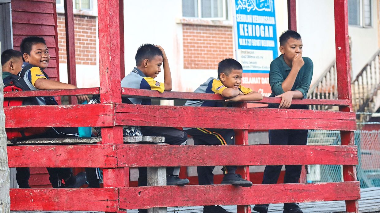 Pupils of SK Keniogan spend time chatting and laughing after school — all of them familiar with one another, as the island has only one primary school.