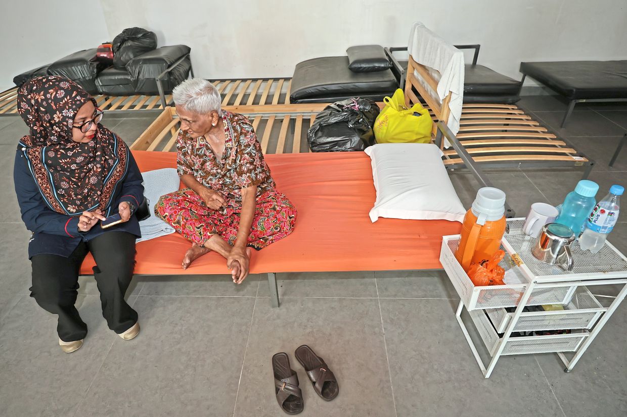 Centre staff member talking to a lodger at the transit centre dormitory.