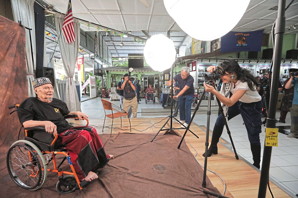 Photographers taking portrait shots of a resident at the mini studio.