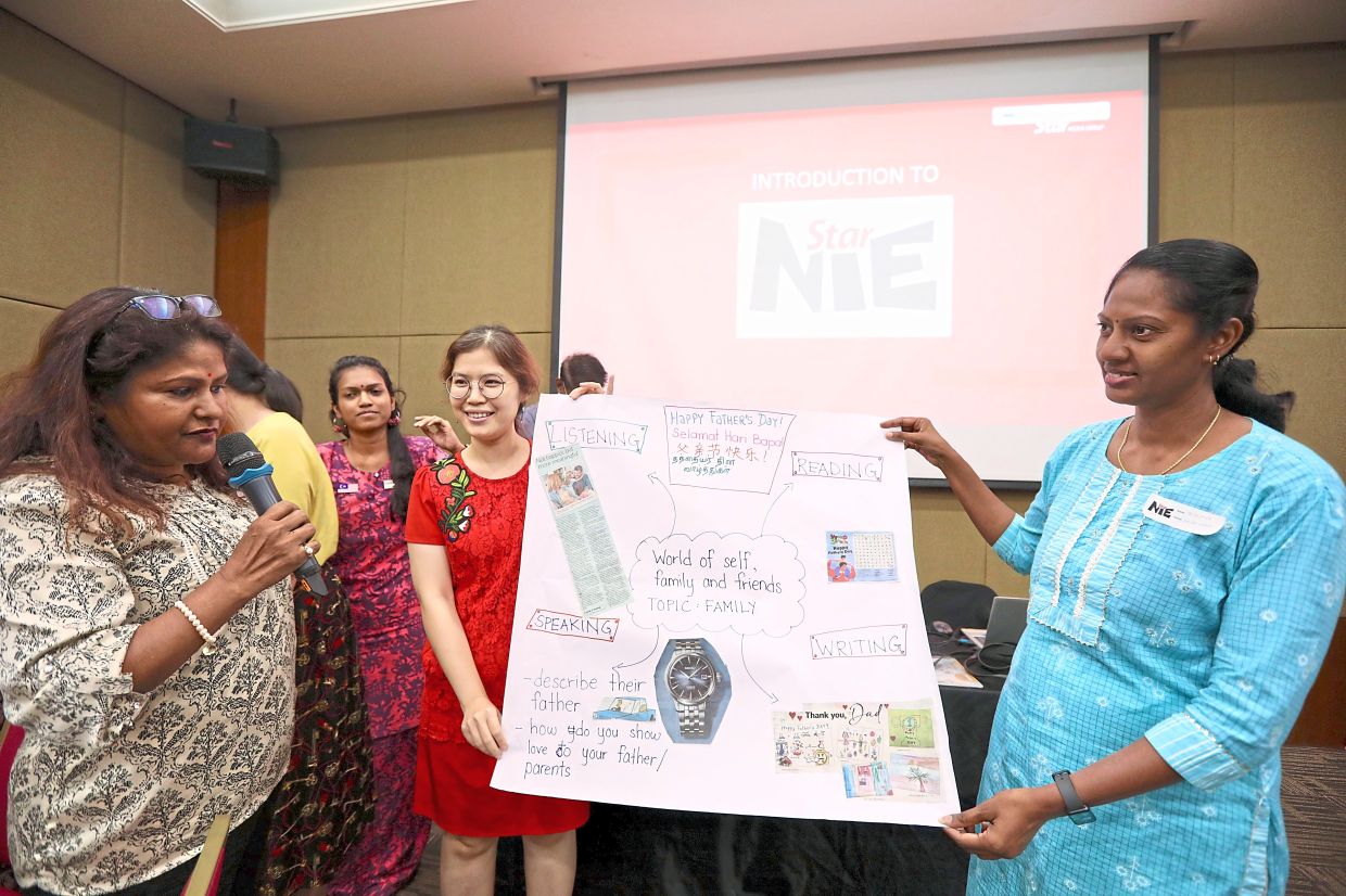 Teachers presenting a mind map of their lesson using newspaper cutouts.