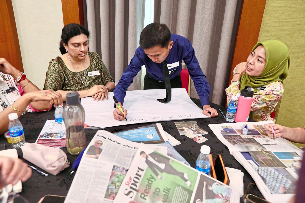 Workshop participants planning their lessons around the use of newspaper content.