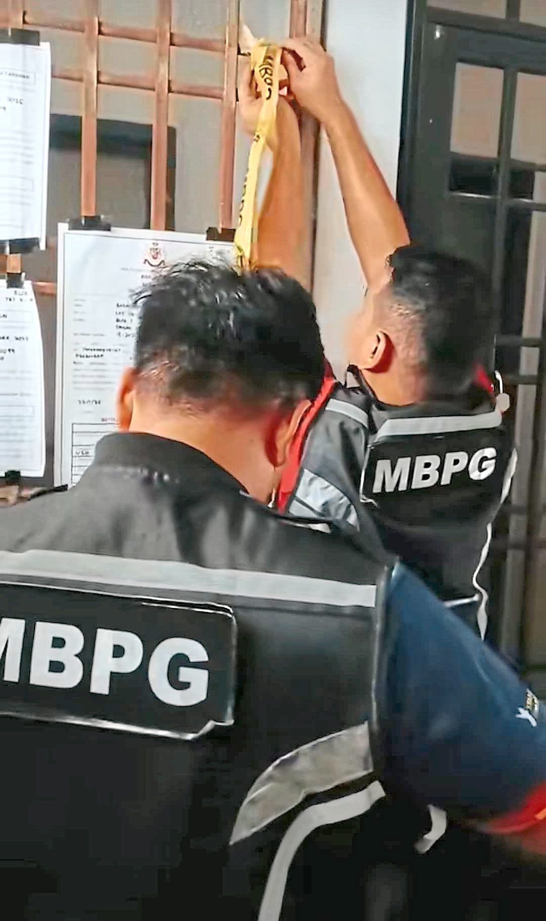 Enforcement officers from Pasir Gudang City Council putting up notices before sealing a premises in their jurisdiction. — Courtesy photo