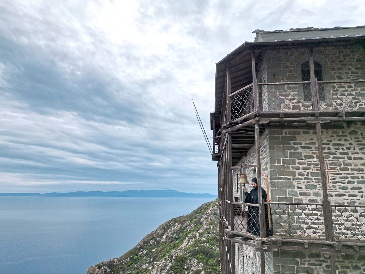 Father Simon tolling the bell to summon monks and visitors to afternoon prayers. — AP