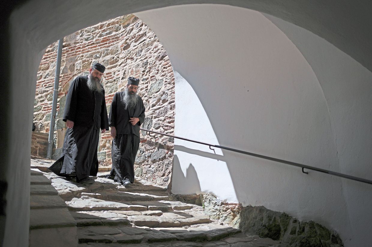 Father Kosmas (left) and Father Nyfmon walking in the Simonopetra. — AP
