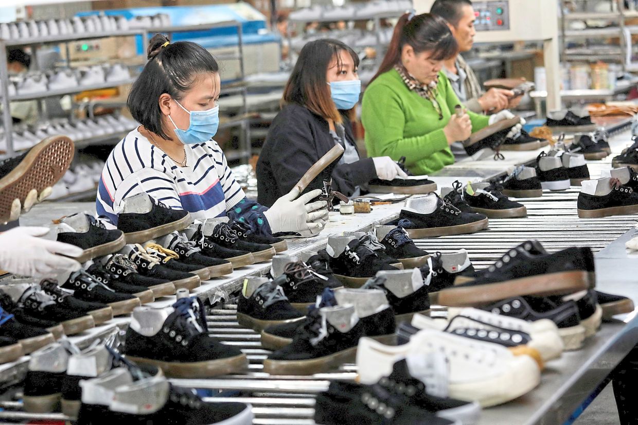 Big industry: A 2020 file photo of employees working at a shoe factory for export in Hanoi. Vietnam is a manufacturing powerhouse that produces clothing and footwear for international brands, with the United States its number-one export market in the first five months of 2025. — Reuters