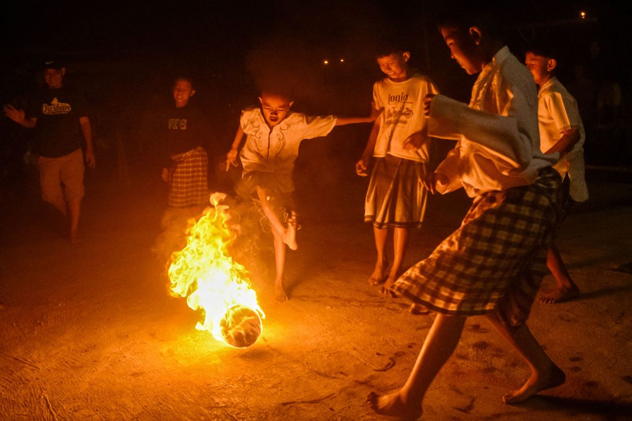 Indonesian Muslim children wearing traditional sarongs play fireball football, known locally as Sepak Bola Api, as part of celebrations marking the beginning of the Islamic New Year in Bandung, West Java. -- Photo by TIMUR MATAHARI / AFP