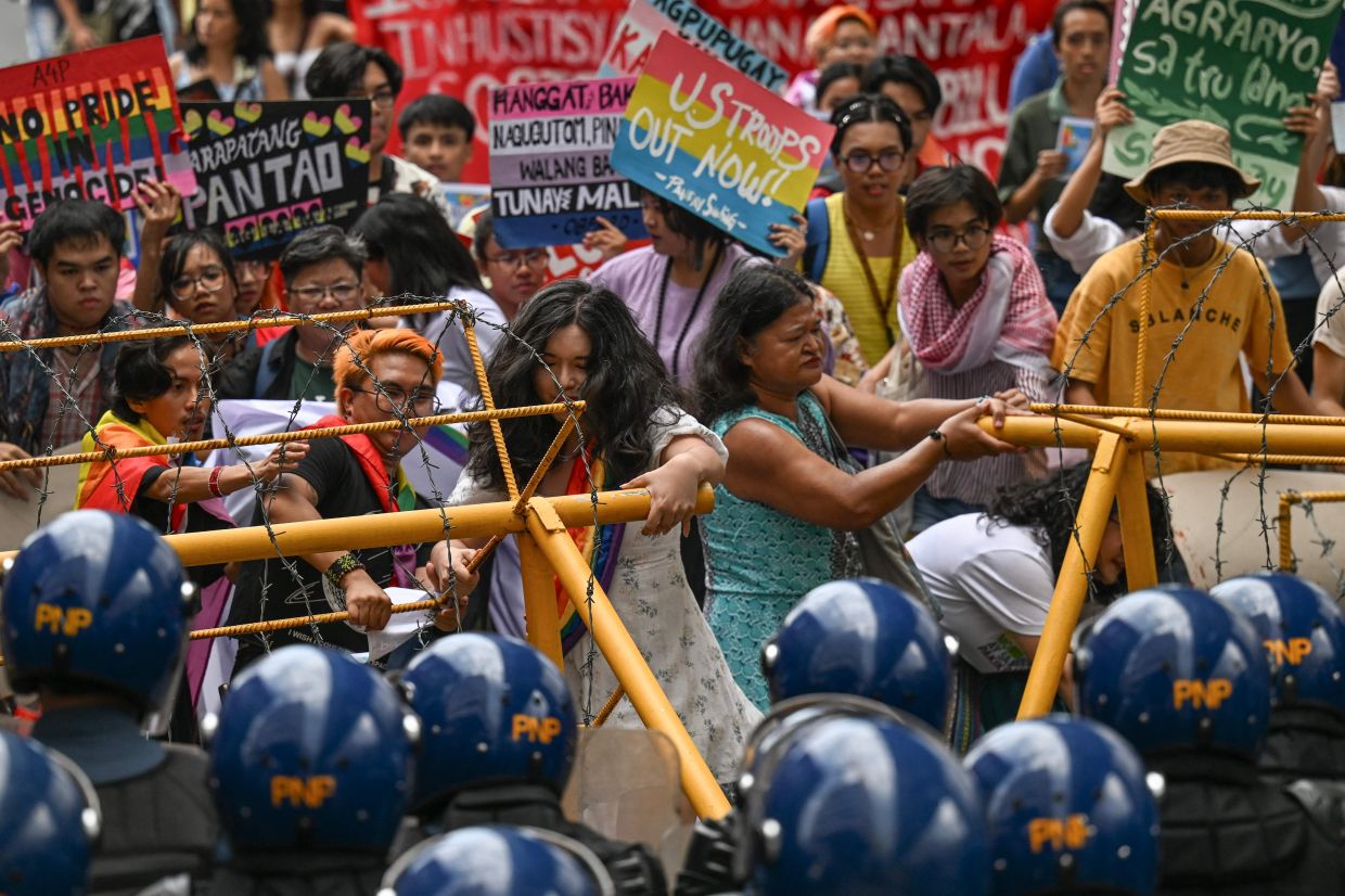 Members of the LGBTQ community remove barricades as they take part in a pride protest held in support of a campaign pushing to pass the Sexual Orientation and Gender Identity Expression (SOGIE) Equality Bill, also known as the Anti-Discrimination Bill (ADB), in Manila. -- Photo by Jam STA ROSA / AFP