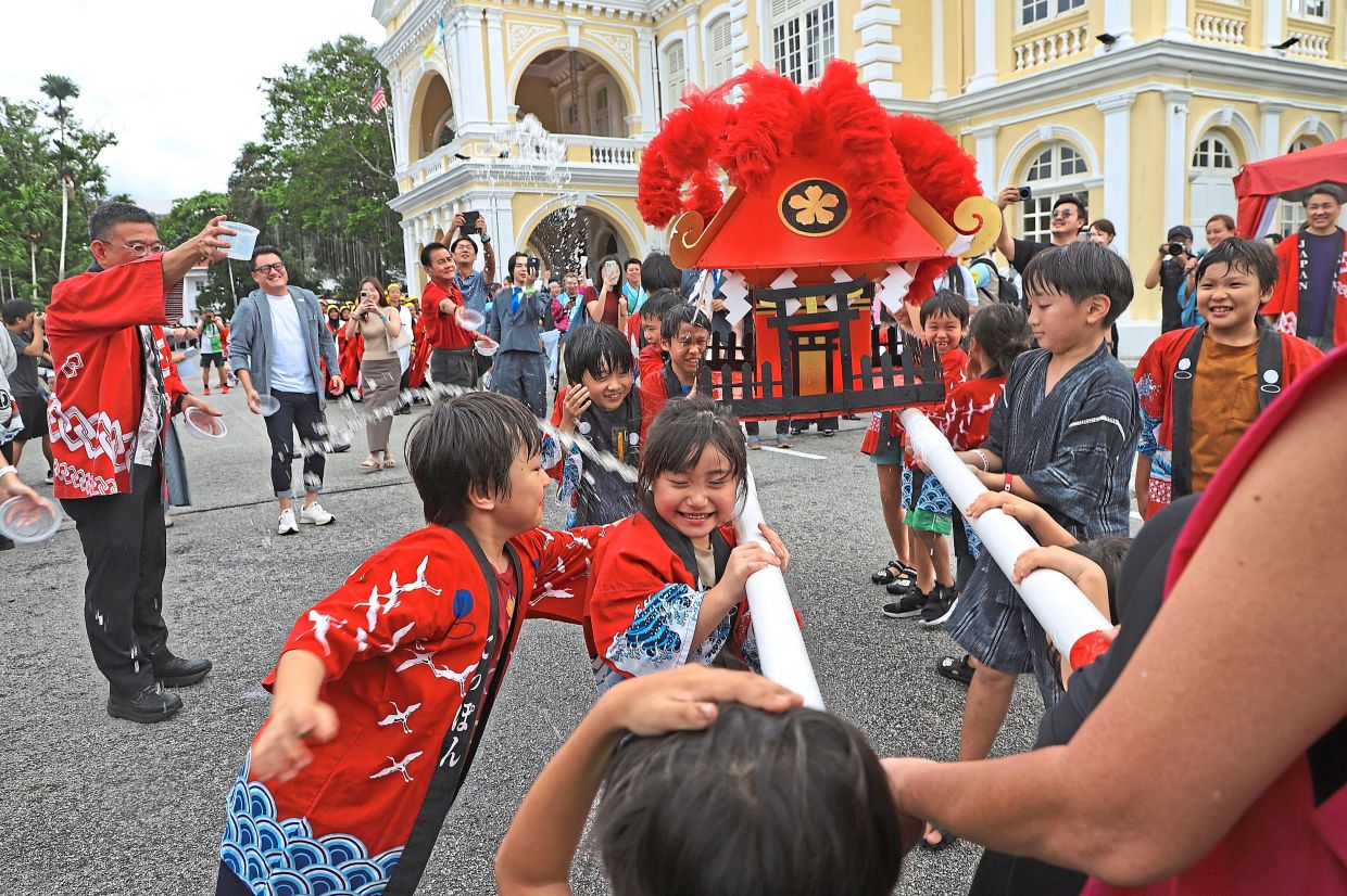 Japanese children carrying a Mikoshi (portable shrine) for the customary water blessing ceremony at the start of Penang Yosakoi Parade 2025
