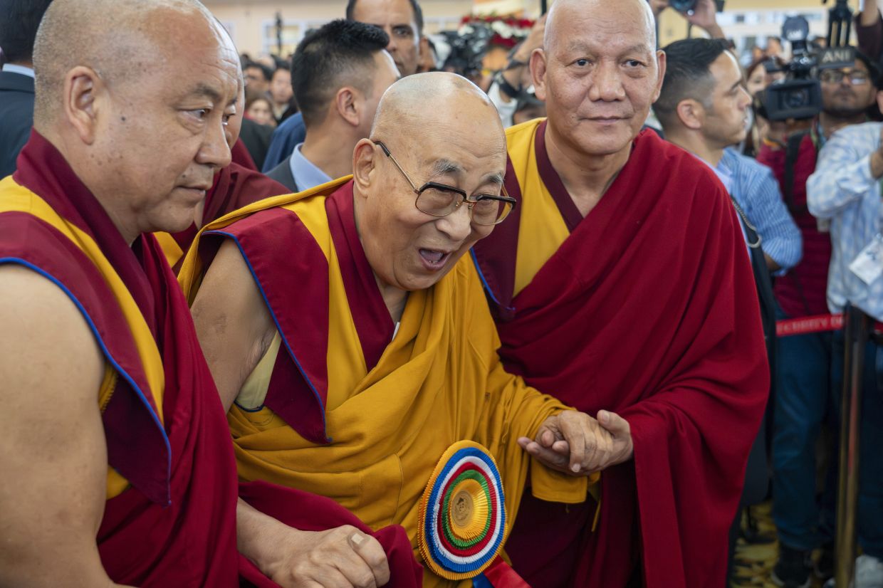 Attendant monks help Tibetan spiritual leader the Dalai Lama to leave after presiding over an event celebrating his 90th birthday according to a Tibetan calendar at the Tsuglakhang temple in Dharamshala, India, Monday, June 30, 2025, ahead of his birthday according to the Gregorian calendar on July 6. - AP Photo/Ashwini Bhatia
